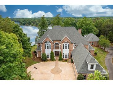 Stunning waterfront home featuring a circular driveway, brick facade, bay windows, and mature landscaping at 3106 47Th Avenue Ne Ln, Hickory, NC 28601