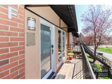 Private entrance with cozy porch, black awning, and contemporary outdoor lighting at 452 S Main St # F, Davidson, NC 28036