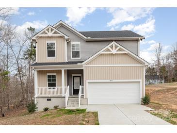 Charming two-story home with a front-facing two car garage and neutral beige and gray vinyl siding at 8915 Myra Way # 39, Charlotte, NC 28215