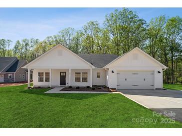 Charming single-story home featuring a well-manicured lawn, attached garage, and inviting covered porch at 902 Westminster Dr, Statesville, NC 28677