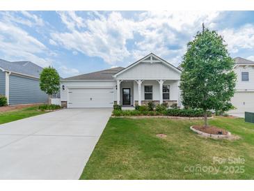 Charming single-story home featuring a two-car garage, landscaped front yard, and inviting covered front porch at 1819 Lotus Ln, Denver, NC 28037