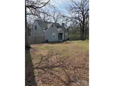 Charming two-story home with a gray exterior, mature trees, and a spacious front yard at 28714 Nc Hwy 24/27 Hwy, Albemarle, NC 28001