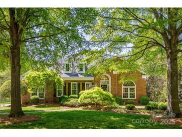 Charming brick home with mature trees, lush lawn, and manicured landscaping at 4340 Sequoia Red Ln, Charlotte, NC 28226