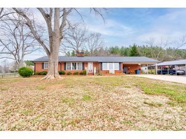 Charming brick home with a well-maintained front yard and mature trees, featuring a carport at 107 Destiny Ln, Shelby, NC 28150