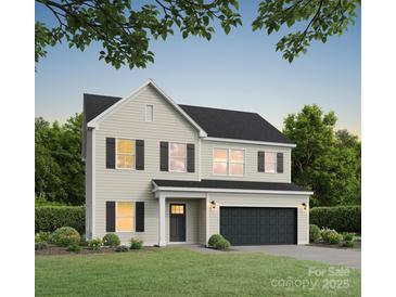 Two-story home featuring a two-car garage, neutral siding, black shutters, and a well-maintained lawn at 5127 Izzo Ln, Charlotte, NC 28214