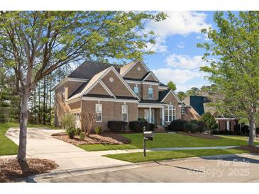 Charming brick two-story home featuring a well-manicured lawn, mature trees, and a classic design at 561 Keystone Nw Ct, Concord, NC 28027