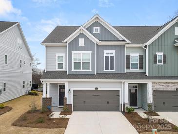 Charming townhome with gray siding, a front-entry garage, and well-maintained landscaping at 9021 Charles Francis Ln, Cornelius, NC 28031