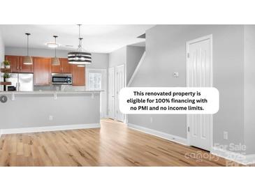 Spacious living room featuring wood floors and an open layout into the kitchen at 12417 Mcgrath Dr, Charlotte, NC 28269