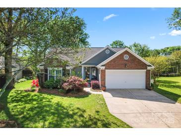 Charming one-story home featuring brick and siding with a two-car garage and beautiful landscaping at 1347 Eisenhower Nw Pl, Concord, NC 28027