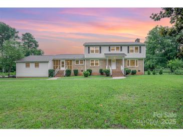 Charming two-story home featuring brick accents, neutral siding, well-manicured landscaping, and a spacious front yard at 16308 Poplar Tent Rd, Huntersville, NC 28078