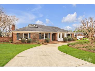 Charming brick home featuring a manicured front lawn and a curved driveway at 1921 Wexford Ct, Gastonia, NC 28054