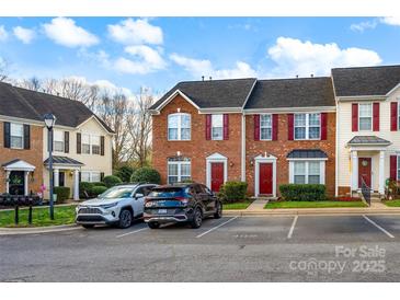 View of townhomes with red shutters, neat landscaping, and car parking at 1965 Charlotte Hwy # 401, Mooresville, NC 28115