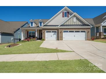 Beautiful brick and siding home showcasing a manicured lawn and a convenient two-car garage at 22014 Finworthy Ln, Huntersville, NC 28078