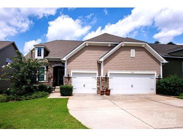 Charming home featuring a two-car garage, stone accents, shake siding, and manicured lawn with lush greenery at 246 Sweet Briar Dr, Fort Mill, SC 29707