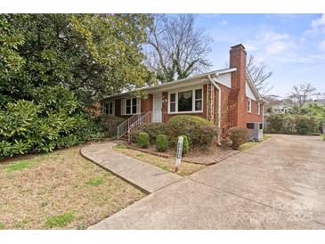 Charming single-story brick home featuring a well-manicured lawn and a concrete driveway at 2922 Dunlavin Way, Charlotte, NC 28205