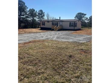 Charming single story home with gravel driveway and inviting front porch and dark shutters at 8183 Hallman Mill Rd, Vale, NC 28168