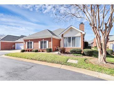 Charming brick home featuring a well-manicured lawn and tidy landscaping under a partly cloudy sky at 8462 Highland Glen Dr, Charlotte, NC 28269