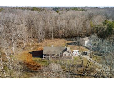 An aerial view of a home surrounded by woods showcasing the property and its surroundings at 1298 Hines Rd, Clover, SC 29710