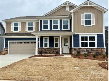 Charming two-story home featuring a two-car garage, stone accents, and a welcoming front porch at 1708 Honey Trl, Monroe, NC 28112