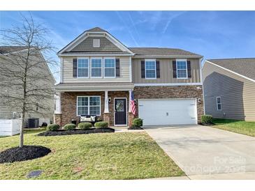 Inviting two-story home with a well-manicured lawn, stone accents, and a two car garage at 181 Atwater Landing Dr, Mooresville, NC 28117