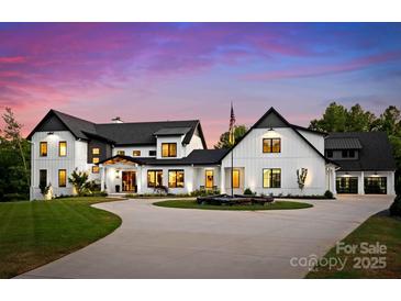 Stunning modern farmhouse with circular drive, manicured lawn, and elegant black and white design at 406 Morrison Farm Rd, Troutman, NC 28166