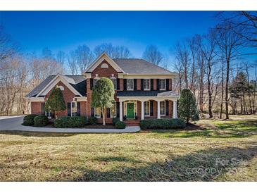 Beautiful brick home with manicured lawn, lush landscaping and a welcoming columned entryway at 4340 Rodeway Ne Ct, Hickory, NC 28601