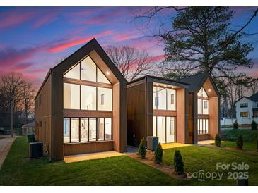 Stunning new construction featuring striking modern design, spacious windows, and lush lawn at 5500 Carmel Rd # 101, Charlotte, NC 28226