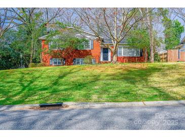 Charming two-story brick home with a well-manicured lawn, shaded by mature trees, creating inviting curb appeal at 5536 Seacroft Rd, Charlotte, NC 28210
