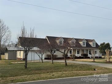 Inviting one-story home boasting a covered front porch, attached garage and large, grassy front lawn at 6795 Jones Rd, Salisbury, NC 28147