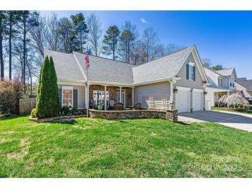 Charming home featuring a well-manicured lawn, stone accents, and a two-car garage at 7331 Sedgebrook W Dr, Stanley, NC 28164