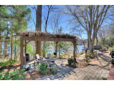 Inviting outdoor patio with lake views, pergola, grill, and cozy seating area perfect for relaxing at 7611 Buckland Rd, Charlotte, NC 28278