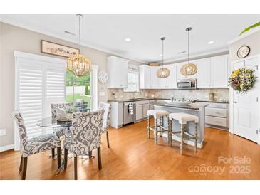 Bright kitchen featuring white cabinets, stainless steel appliances, granite countertops and eat in breakfast nook at 963 Brookdale Ln, Stanley, NC 28164