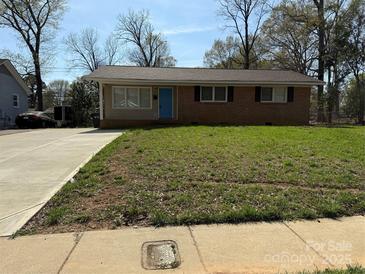Charming single-story brick home with a well-maintained lawn and a bright blue front door at 1111 Pondella Dr # 66, Charlotte, NC 28213