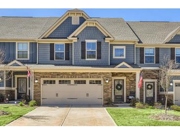Charming townhome with a stone facade, two-car garage, and well-manicured lawn at 125 Lanyard Dr # E, Mooresville, NC 28117