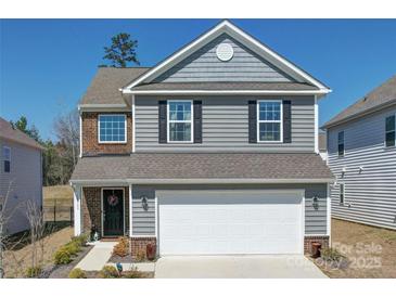 Charming two-story home features a two-car garage, brick and siding accents, and a well-maintained front yard at 15308 Lake Ridge Rd, Charlotte, NC 28278