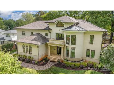 Stately home boasts a turret, manicured landscaping, and inviting column-supported front entryway at 1665 Sterling Rd, Charlotte, NC 28209