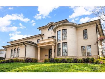 Elegant house features a rounded tower section, classic columns, and landscaped grounds under a bright sky at 1665 Sterling Rd, Charlotte, NC 28209