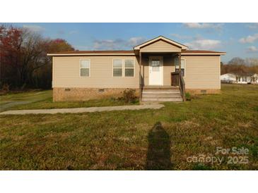Charming single story home featuring a small porch, traditional windows, and vinyl siding at 1909 E Lawyers Rd, Monroe, NC 28110
