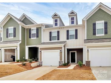 Inviting townhome featuring a one car garage and manicured lawn at 2749 Yeager Nw Dr, Concord, NC 28027