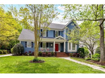 Charming two-story home with a welcoming front porch, red door, and well-manicured lawn at 306 Ashby Dr, Davidson, NC 28036