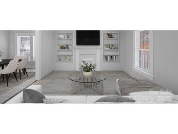 Bright living room featuring neutral walls, carpet, and built-in shelving at 310 Pineview St, Kannapolis, NC 28083