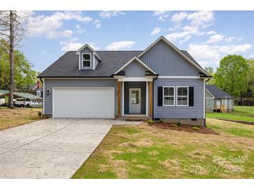 Charming home featuring a two-car garage, dormer window, and gray siding at 409 Bost St, Kannapolis, NC 28081