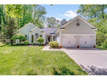 Charming home with a well-manicured lawn, lush landscaping, and a two-car garage at 11003 Pale Hickory Ln, Charlotte, NC 28215
