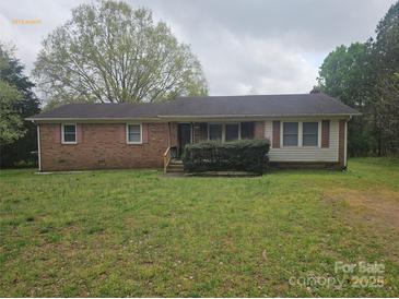 Charming single-story brick home with a well-maintained yard and inviting covered front porch at 13316 E Rocky River Rd, Davidson, NC 28036