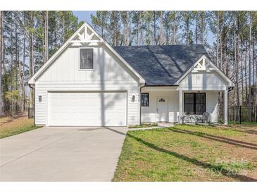 Charming craftsman home featuring white siding, a two-car garage, and a cozy front porch at 13625 Buster Rd, Stanfield, NC 28163
