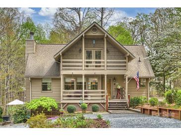 Charming home features a porch with an American flag, beautiful landscaping, and a welcoming entrance at 2819 Blythe Rd, Waxhaw, NC 28173