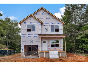 Two-story home under construction showing wrap, windows, and porch in a wooded setting with a blue sky at 5005 County Home Rd, Conover, NC 28613