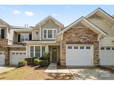 Charming townhome with stone accents, a one-car garage, and a well-manicured front yard at 5959 Pale Moss Ln, Charlotte, NC 28269