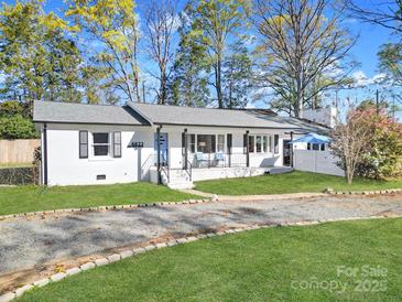 Charming white-painted home featuring a well-manicured lawn and an inviting entrance at 6823 City View Dr, Charlotte, NC 28212