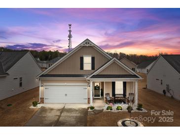 Charming single-story home featuring a covered porch with rocking chairs and a well-manicured front yard at 7172 Indigo Way, Denver, NC 28037